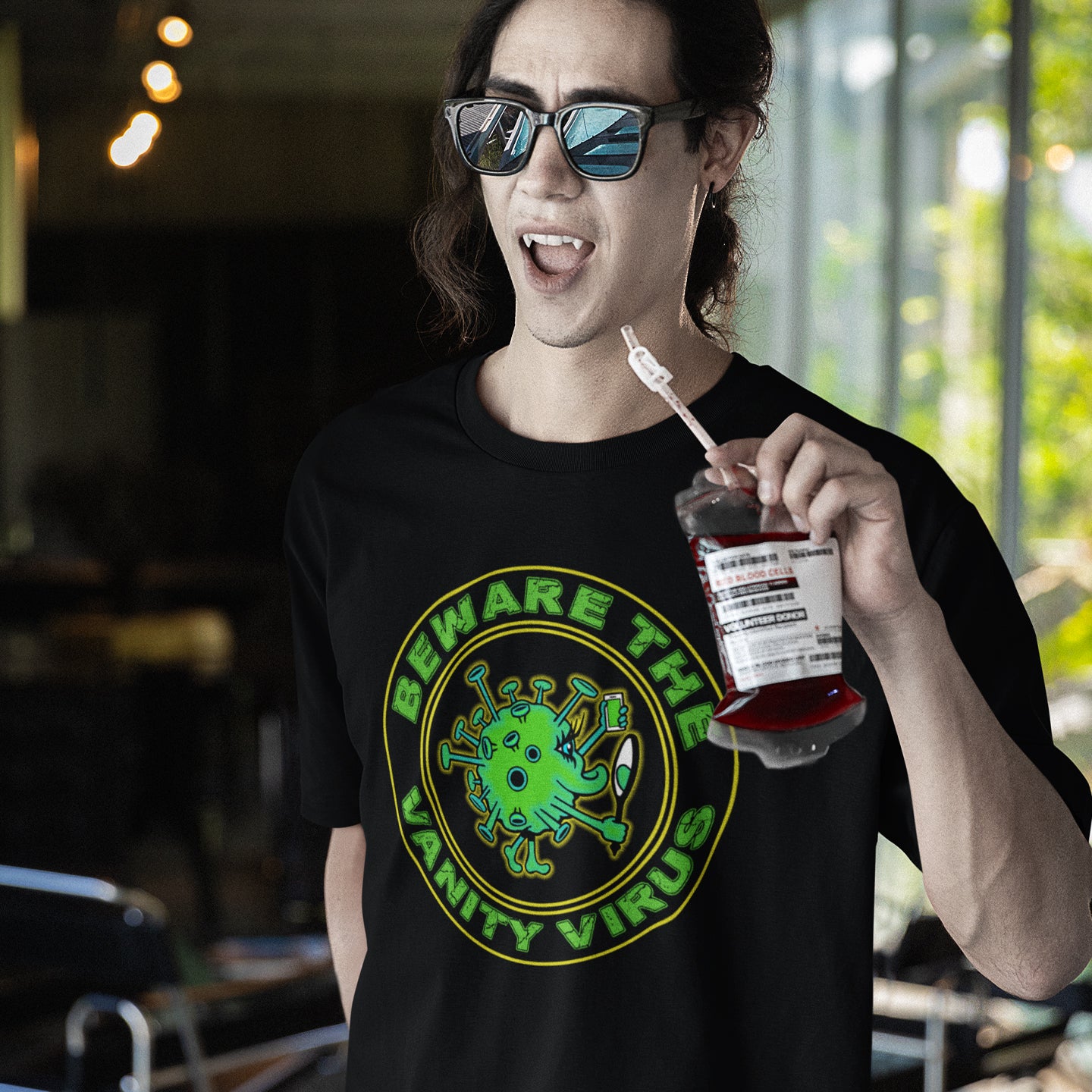 Person wearing a black t-shirt with a graphic design and holding a drink. This satirical counterculture t-shirt suggest there are some nasty viruses out there and vanity is one of the oldest. This unique t-shirt design promotes social awareness of the dangers of vanity because it's a bitch once it takes hold. Made from 100% organic ring-spun cotton, this witty counterculture t-shirt is unisex, high-quality, super comfy, and best of all, eco-friendly.