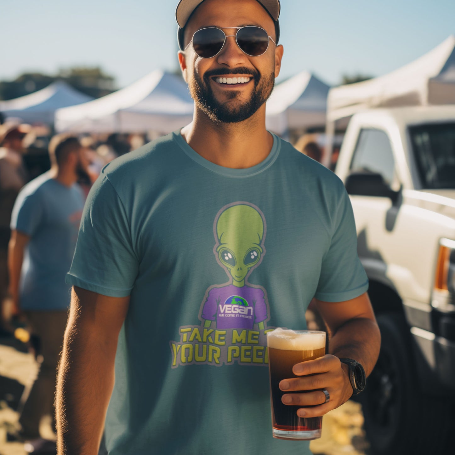 Man wearing a t-shirt with an alien graphic and text, holding a beer at a festival. A plant based t-shirt design for anyone that thinks aliens must be vegans, otherwise they would have been farming us years ago. This unique alien design is for all those conspiracy theorists out there. Made from 100% organic ring-spun cotton, this vegan t-shirt is unisex, high-quality, super comfy, and best of all, eco-friendly.