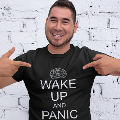 Man wearing a black t-shirt with 'Wake Up and Panic' text and pointing at it, white brick wall background. This satirical 'stay calm' anti-establishment t-shirt suggests we have been calm too long and need of waking up and panic. Keeping calm got us into this mess, it's time to wake up. 100% organic ring-spun cotton, this anti-government t-shirt is unisex, high-quality, super comfy, and best of all, eco-friendly.