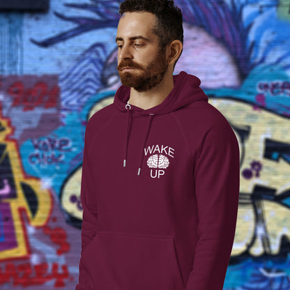 Man wearing a burgundy hoodie with 'Wake Up' text, standing in front of colourful graffiti. This satirical 'stay calm' rebellion hoodie suggests we have been calm too long and need of waking up and panic. Keeping calm got us into this mess, it's time to wake up. Comfortable and practical. It's extra soft and has a convenient front pouch pocket. Made from organic cotton and recycled polyester, this activist hoodie is a great eco-friendly choice.