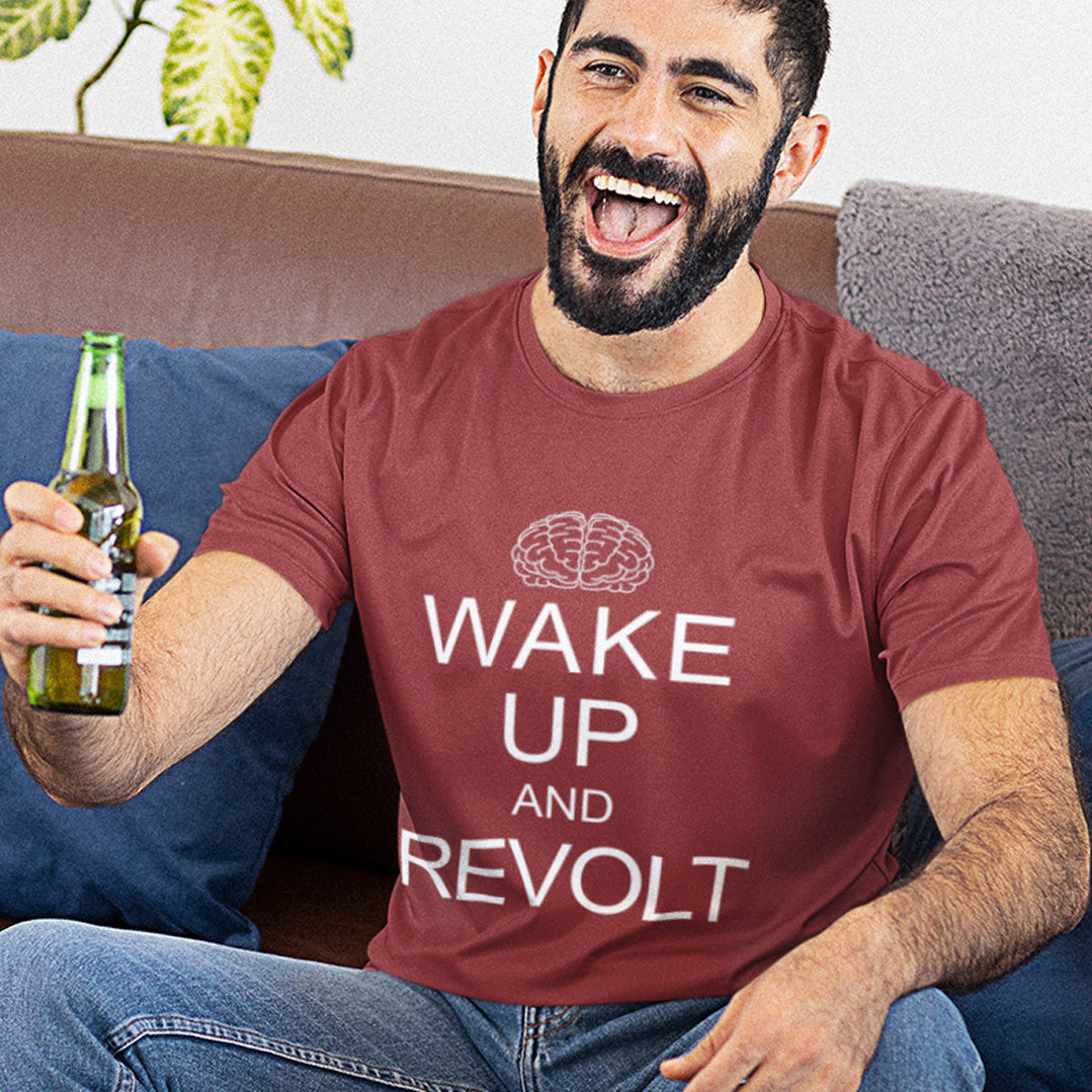 Man wearing a red t-shirt with 'Wake Up and Revolt' text, holding a beer bottle on a couch. This satirical 'stay calm' anti government t shirt suggests we have been calm too long and need of waking up and fighting for our right instead. Keeping calm got us into this mess, it's time to wake up. Made from 100% organic ring-spun cotton, this activist t shirt design is unisex, high-quality, super comfy, and best of all, eco-friendly.