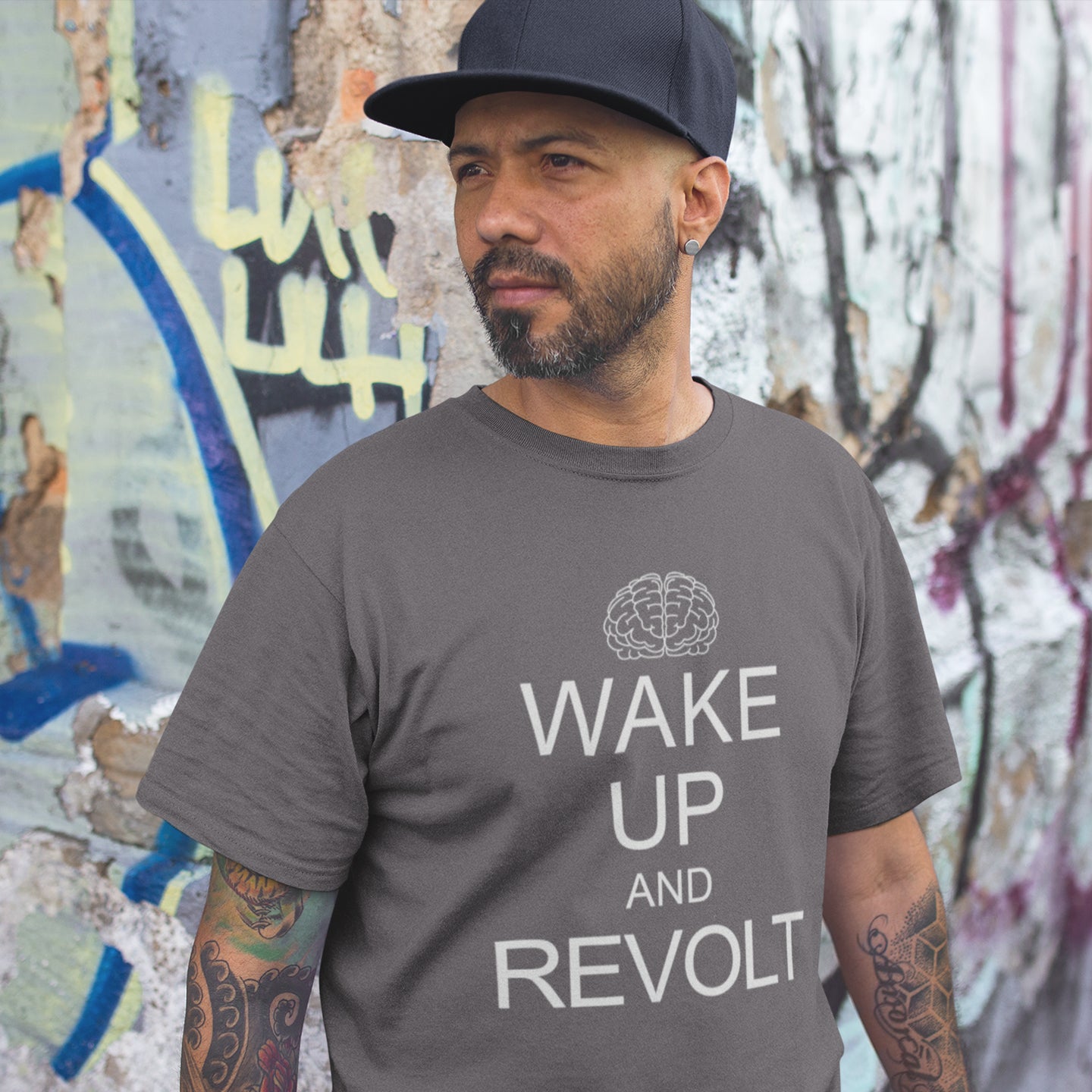 Man wearing an anthracite t-shirt with 'Wake Up and Revolt' text in front of a graffiti-covered wall. This satirical 'stay calm' t-shirt suggests we have been calm too long and need of waking up and fighting for our right instead. Keeping calm got us into this mess, it's time to wake up. Made from 100% organic ring-spun cotton, this counterculture t-shirt is unisex, high-quality, super comfy, and best of all, eco-friendly.