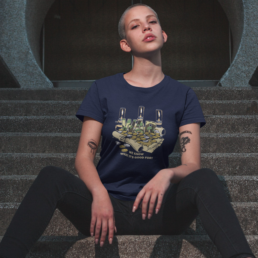 A person sitting on concrete stairs wearing a navy blue graphic t-shirt with a hand holding cash and the text 'WAR".