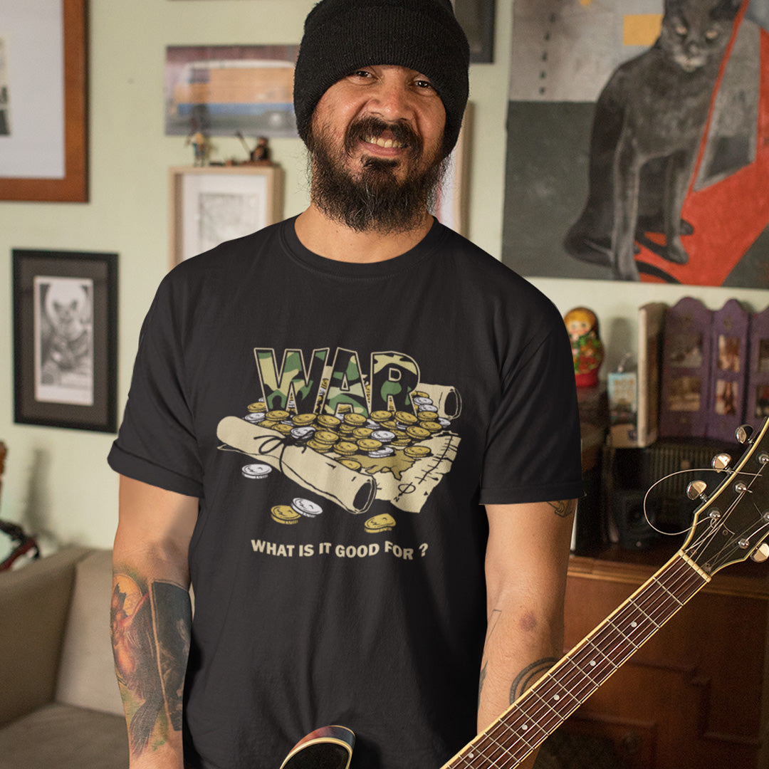 Man wearing a black t-shirt with 'WAR' graphic and text, holding a guitar in a room with framed pictures on the wall. A satirical anti-war t-shirt suggesting we know what it's good for, money and land deeds for starters. Expose the big business of War with this unique design made for any anti-war demonstration. Made from 100% organic ring-spun cotton, this political t-shirt is unisex, high-quality, super comfy, and best of all, eco-friendly.