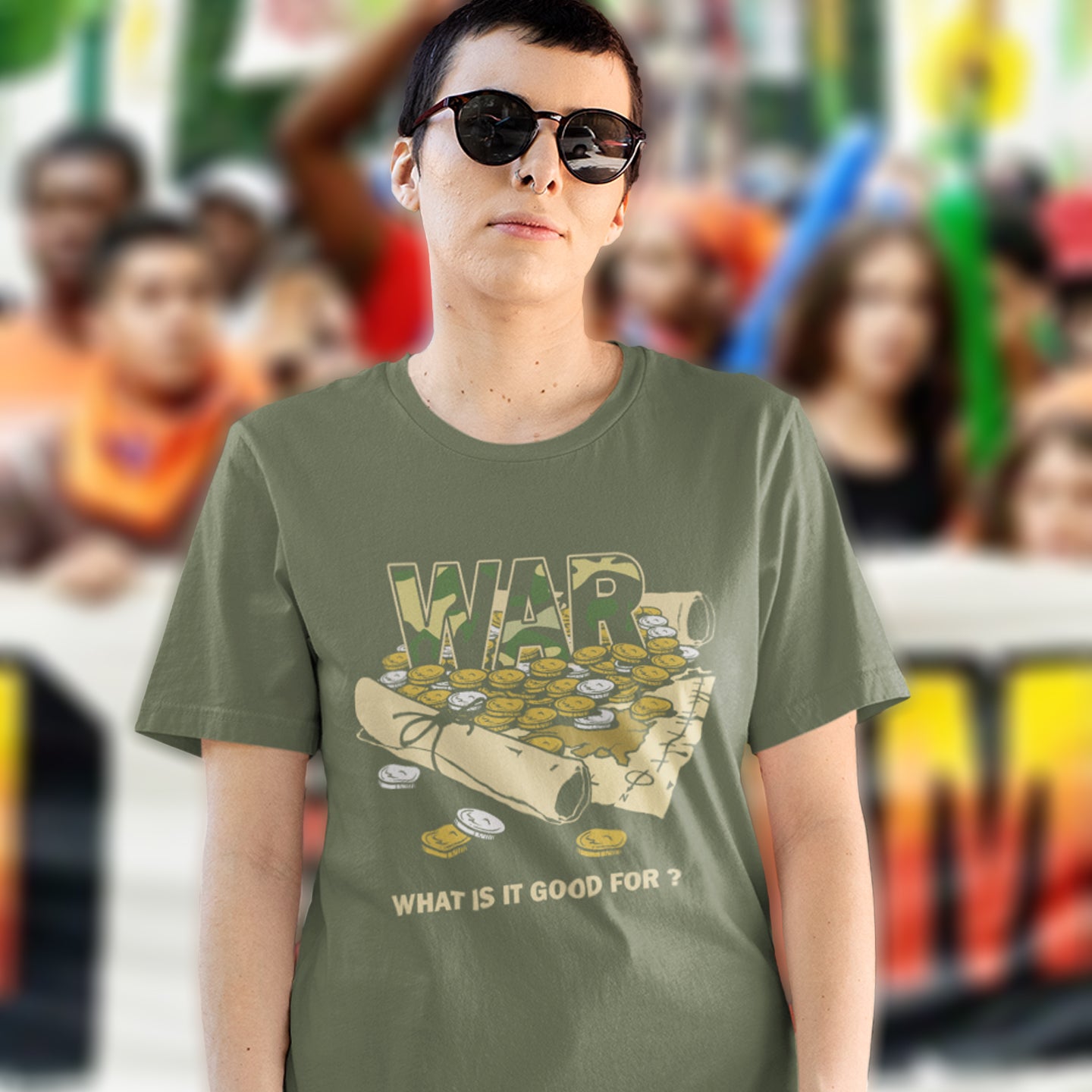 Person wearing a green t-shirt with a graphic design and text, standing in front of a blurred crowd. A satirical anti-war t-shirt suggesting we know what it's good for, money and land deeds for starters. Expose the big business of War with this unique design made for any anti-war demonstration. Made from 100% organic ring-spun cotton, this political t-shirt is unisex, high-quality, super comfy, and best of all, eco-friendly.