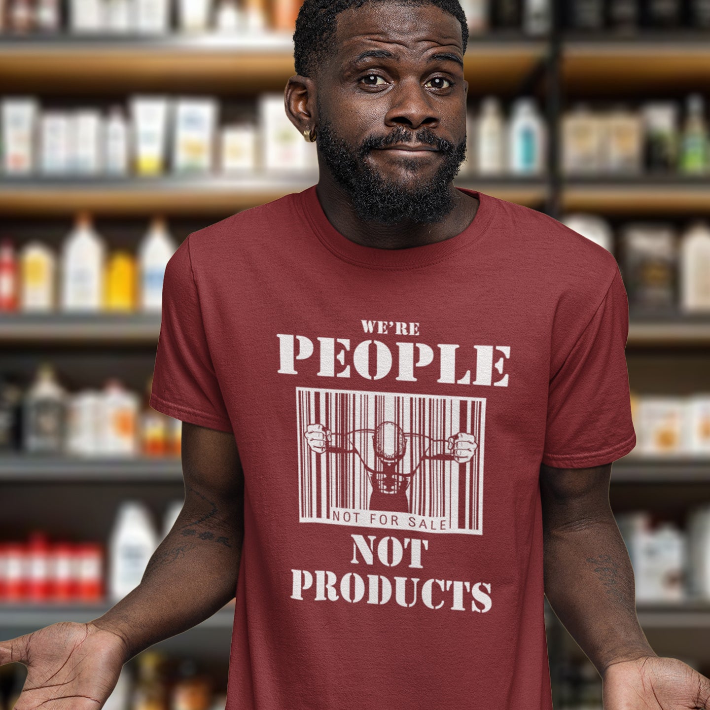 Man standing in a shop wearing a burgundy ' we're people not products' t shirt. An anti capitalism t shirt highlighting the dehumanisation of people in a money obsessed society. A fantastic choice for any anti capitalism protest or to just create social awareness. Made from 100% organic ring-spun cotton, this anti consumerism t shit is unisex, high-quality, super comfy, and best of all, eco-friendly.
