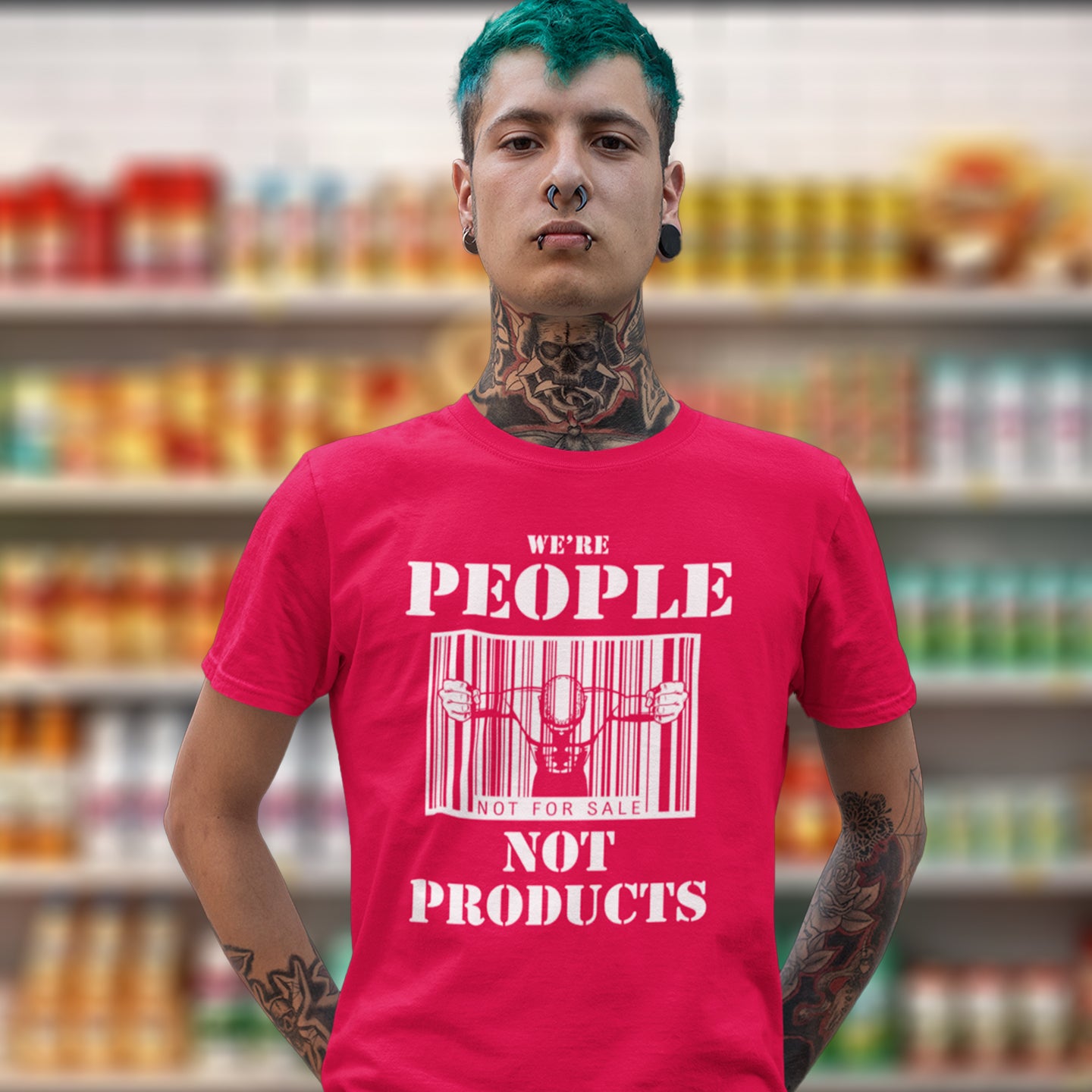 Man wearing a red t-shirt with 'we're people not products' t shirt. An anti capitalism t shirt highlighting the dehumanisation of people in a money obsessed society. A fantastic choice for any anti capitalism protest or to just create social awareness. Made from 100% organic ring-spun cotton, this anti consumerism t shit is unisex, high-quality, super comfy, and best of all, eco-friendly.