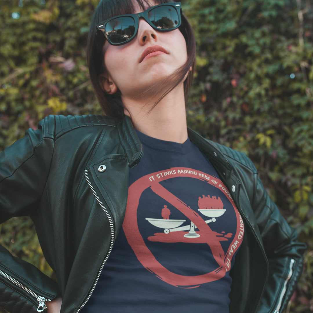 A woman wearing a black leather jacket and a navy blue graphic t-shirt with a red and white 'No Eating Disorders' design, set against a blurred green outdoor background.