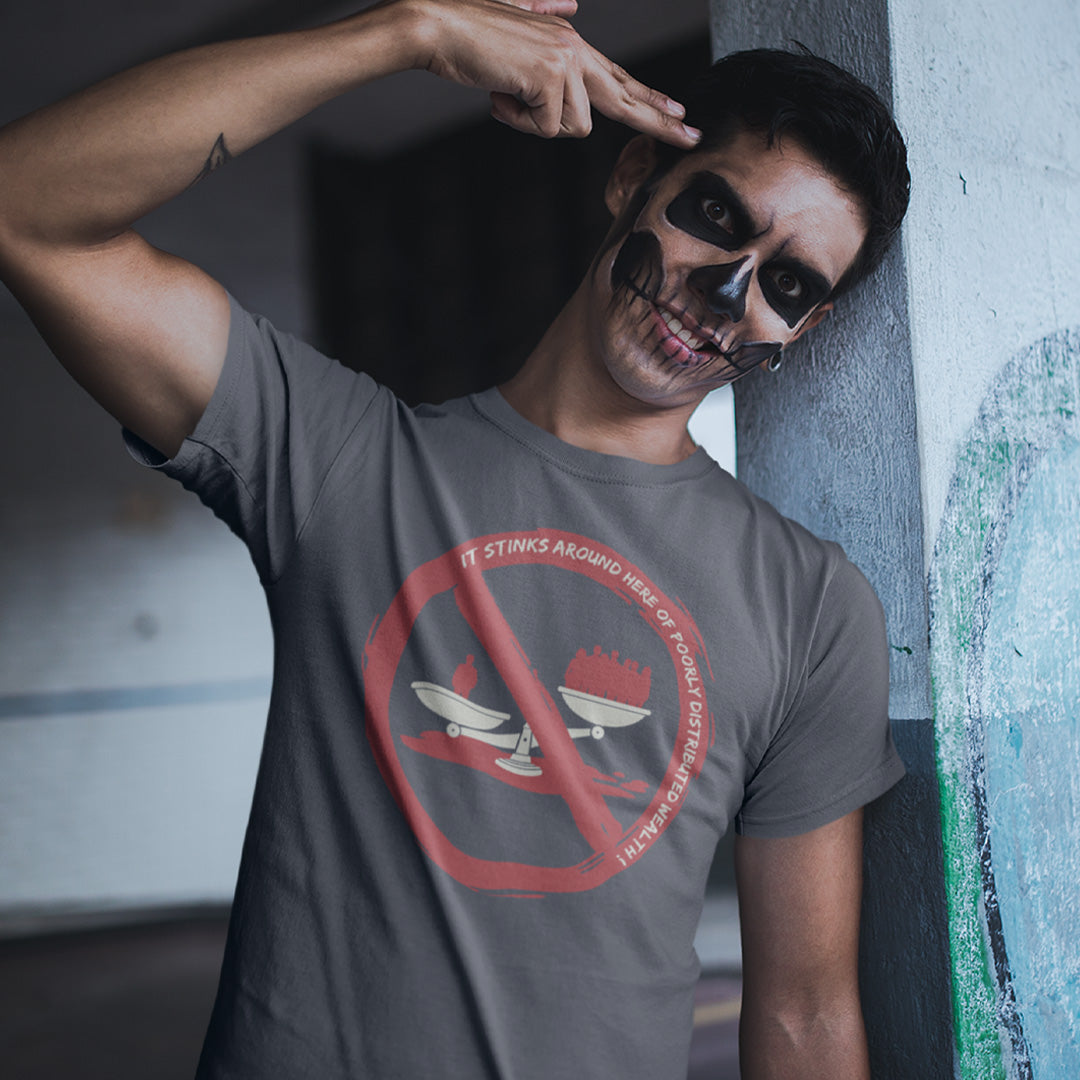 A man wearing a dark gray graphic t-shirt with a red prohibition sign over a skull and crossed swords design, posing against a concrete wall.