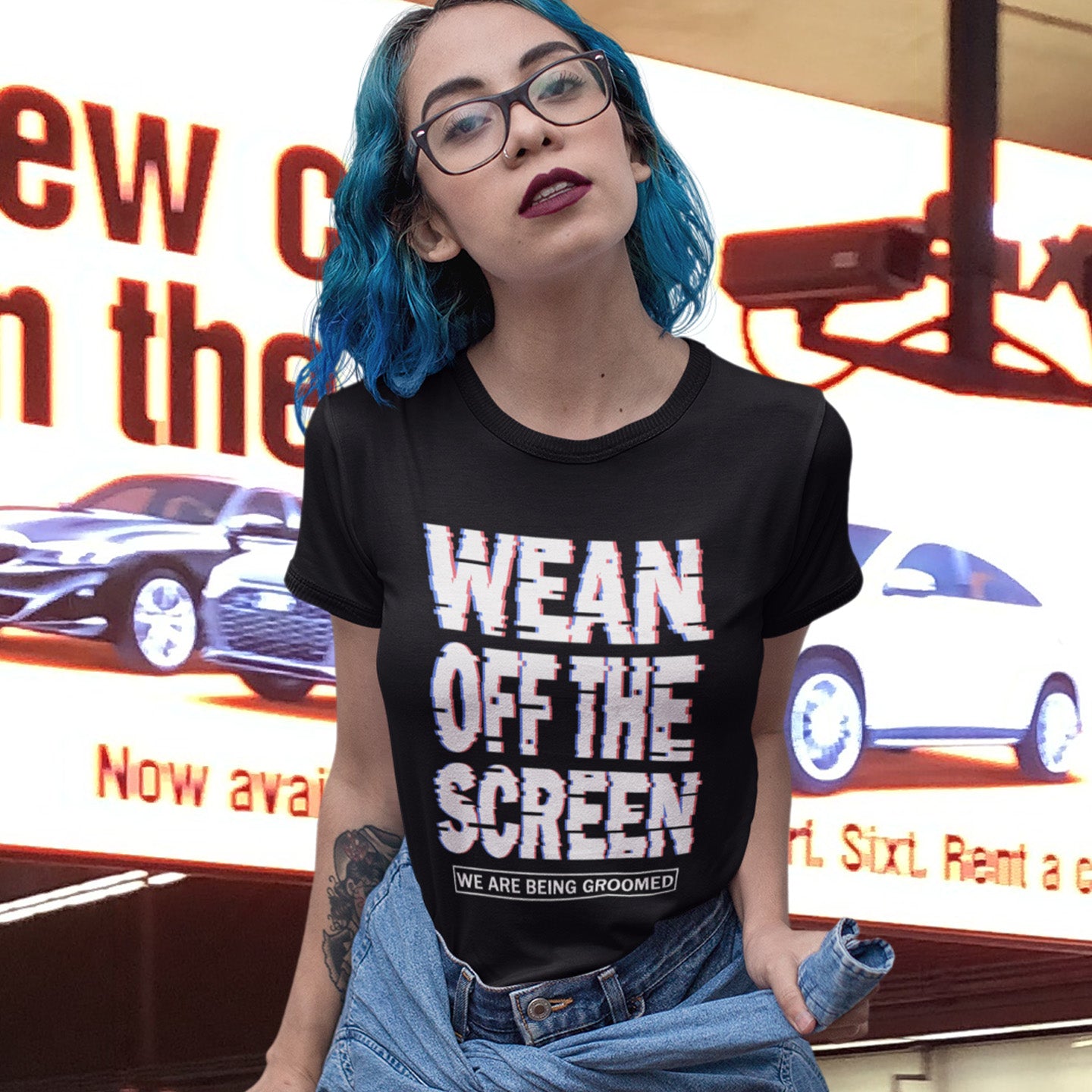 Person wearing a black t-shirt with 'Wean Off The Screen' text in front of a car advertisement. This media based conspiracy theory t-shirt suggests there is more to digital media and entertainment than meets the eye. An anti mobile abuse slogan in a unique design to increase social awareness of too much screen time. Made from 100% organic ring-spun cotton, this conspiracy theory t-shirt is unisex, high-quality, super comfy, and best of all, eco-friendly.