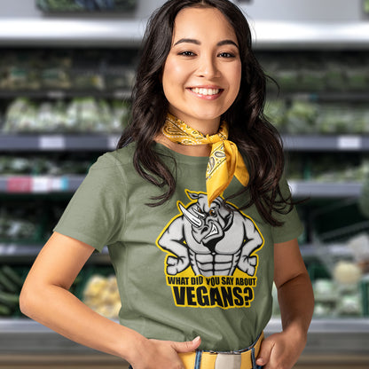 A woman standing in a supermarket, wearing a yellow scarf around her neck and a khaki green short sleeved crew neck t-shirt with a cartoon Rhino design and the caption "WHAT DID YOU SAY ABOUT VEGANS?".