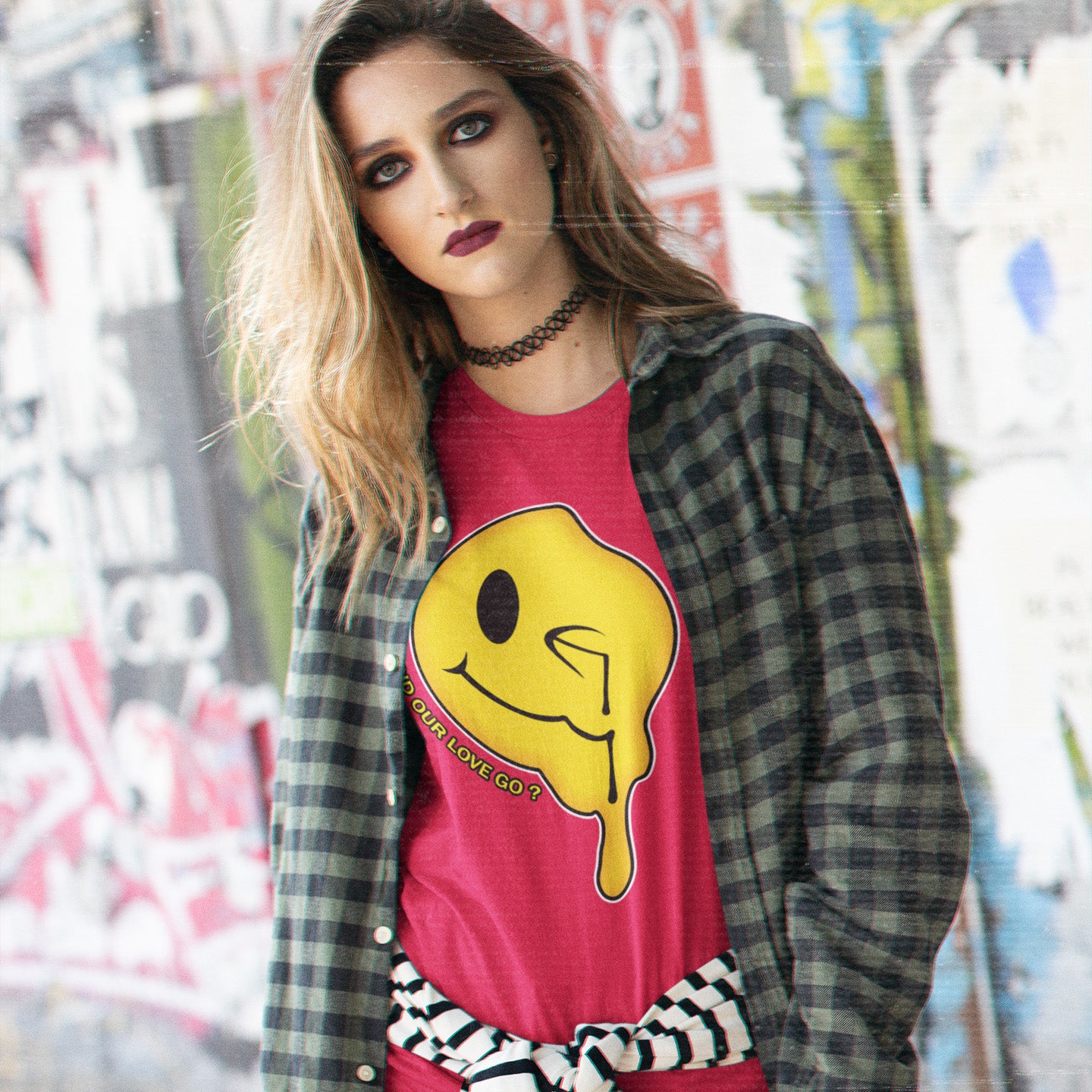 Woman wearing a red shirt with a yellow graphic design in an urban setting. An old skool 90's acid house t shirt. This design is a tribute to 90's house music and the love that was felt around the scene. What happened ? Made from 100% organic ring-spun cotton, this 90's acid house t shirt is unisex, high-quality, super comfy, and best of all, eco-friendly.