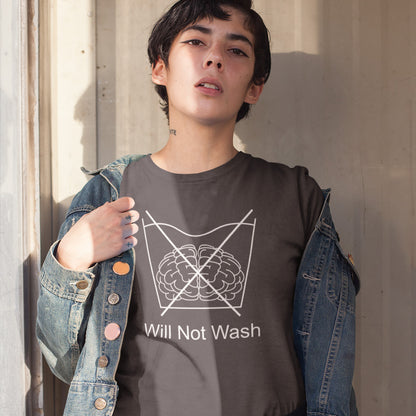 Girl standing in doorway. A self worth t shirt promoting a strong mind and a resistance to brainwashing. this unique anti-establishment t-shirt design is a play on washing instructions and highlights the mass influence and indoctrination in modern society. Made from 100% organic ring-spun cotton, this clever slogan t shirt is unisex, high-quality, super comfy, and best of all, eco-friendly.