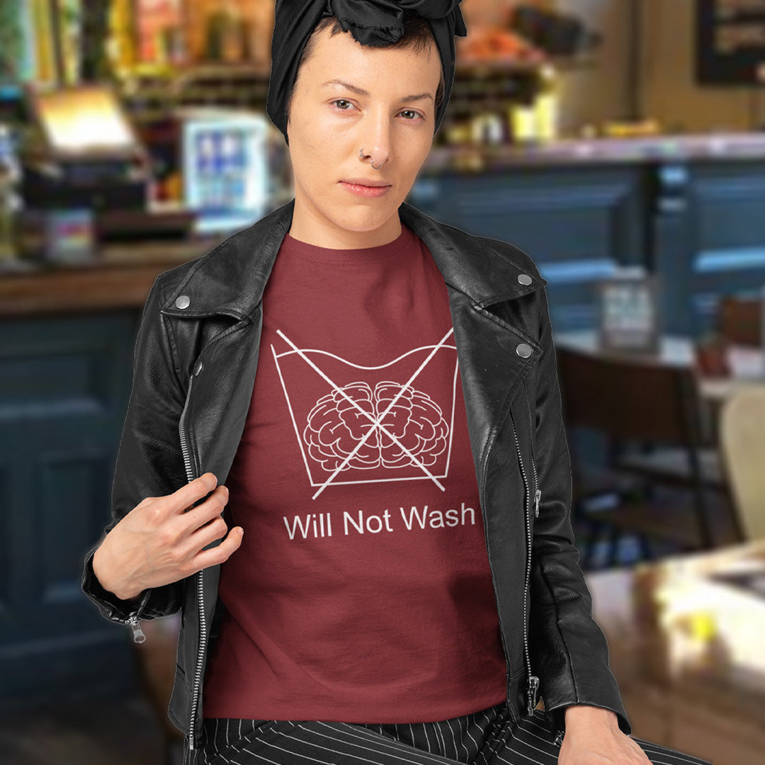 Woman sat in a bar. A self worth t shirt promoting a strong mind and a resistance to brainwashing. this unique anti-establishment t-shirt design is a play on washing instructions and highlights the mass influence and indoctrination in modern society. Made from 100% organic ring-spun cotton, this clever slogan t shirt is unisex, high-quality, super comfy, and best of all, eco-friendly.