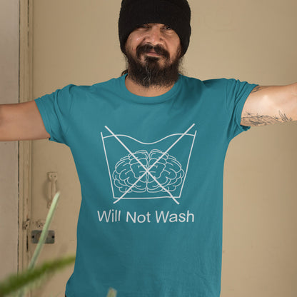 Man wearing a stargazer t-shirt with a graphic and text 'Will Not Wash' in a home setting. A self worth t shirt promoting a strong mind and a resistance to brainwashing. this unique anti-establishment t-shirt design is a play on washing instructions and highlights the mass influence and indoctrination in modern society. Made from 100% organic ring-spun cotton, this clever slogan t shirt is unisex, high-quality, super comfy, and best of all, eco-friendly.