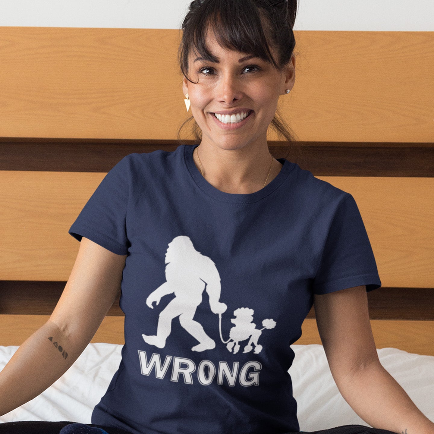 Woman wearing a French navy blue t-shirt with a graphic design and the word 'WRONG' sitting on a wooden floor. A funny Bigfoot t-shirt questioning the limits of acceptability. A poodle will never be the dog of choice for the Bigfoot. However open minded you are there are some things that will never look right. Made from 100% organic ring-spun cotton, this funny bigfoot t shirt is unisex, high-quality, super comfy, and best of all, eco-friendly.