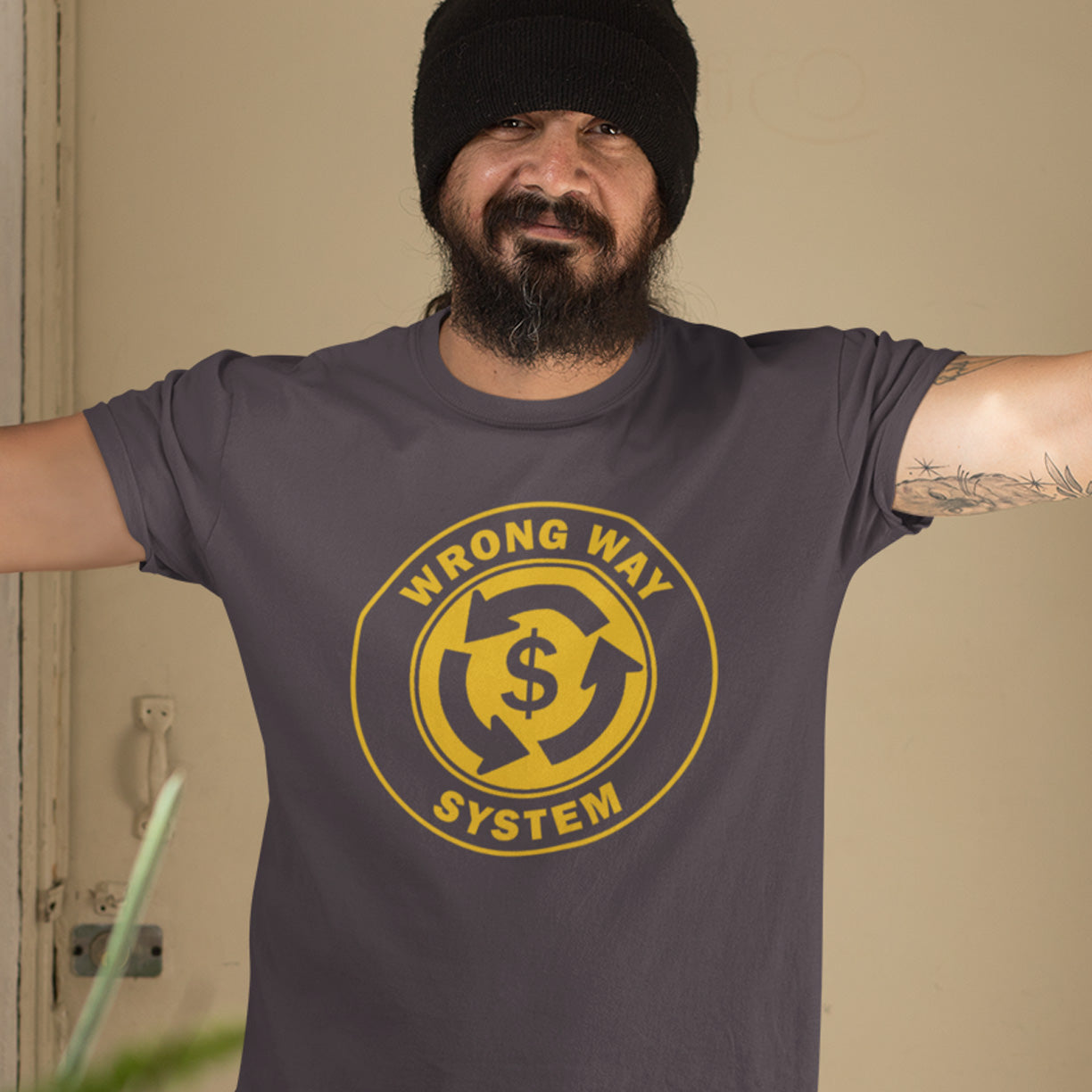 Man wearing a anthracite t-shirt with a yellow graphic and text, standing against a beige wall. A political t-shirt in the form of a road sign reminder that it's possibly not been the best idea to build our society around money. Wrong direction, change the system ! Made from 100% organic ring-spun cotton, this social awareness political t-shirt is unisex, high-quality, super comfy, and best of all, eco-friendly. A great choice for an anti-capitalist socio-economic demonstration.