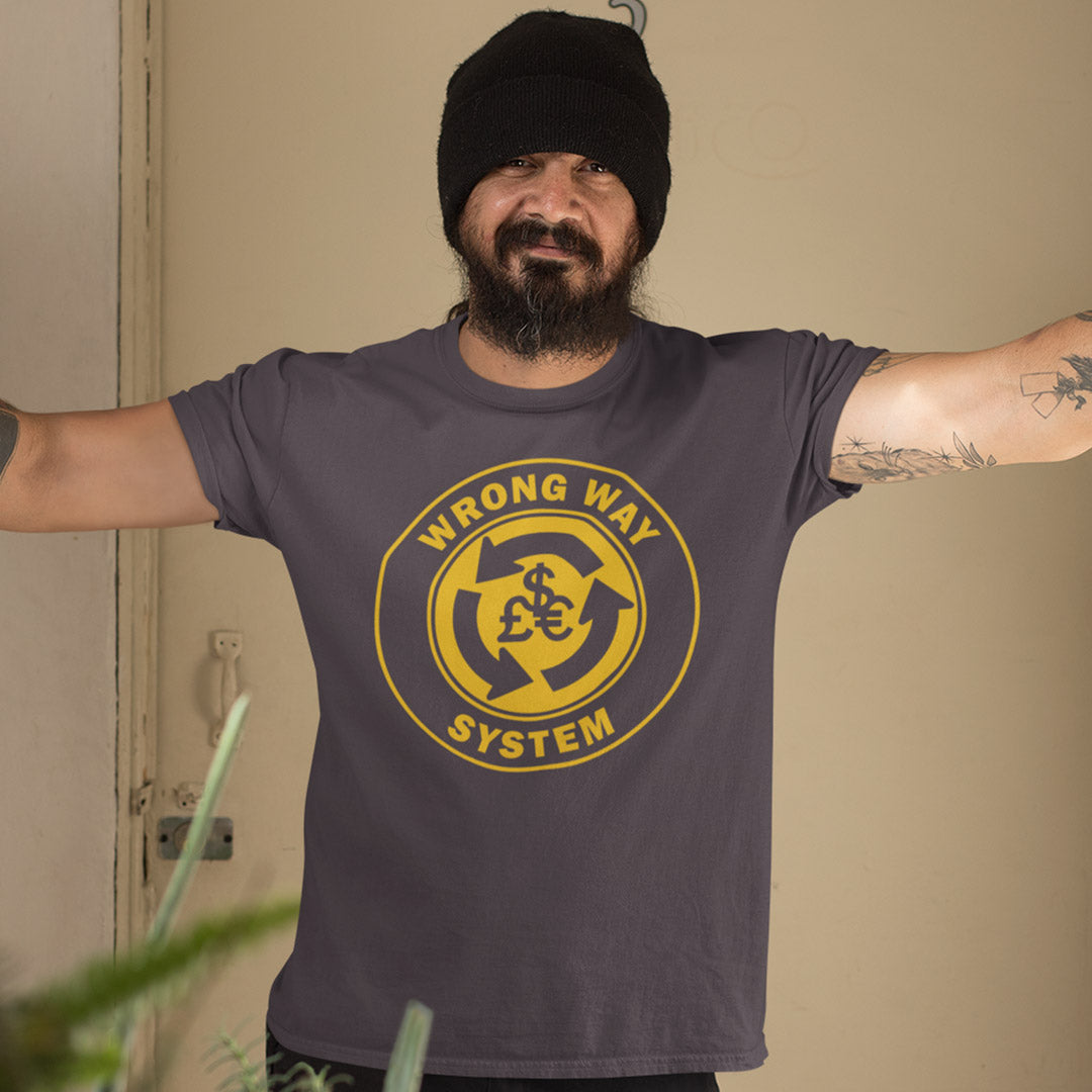 Man wearing a grey t-shirt with a yellow graphic and text, standing against a beige wall. A non conformist t shirt in the form of a road sign reminder that it's possibly not been the best idea to build our society around money. Wrong direction, change the system ! Made from 100% organic ring-spun cotton, this social awareness t shirt is unisex, high-quality, super comfy, and best of all, eco-friendly. A great choice for an anti capitalist socio economic demonstration.