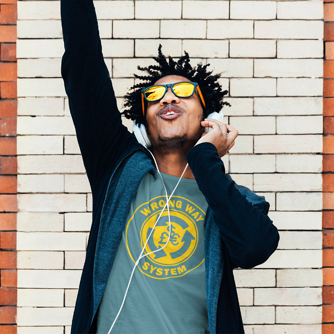 Man wearing sunglasses and a graphic t-shirt against a brick wall. A non conformist t shirt in the form of a road sign reminder that it's possibly not been the best idea to build our society around money. Wrong direction, change the system ! Made from 100% organic ring-spun cotton, this social awareness t shirt is unisex, high-quality, super comfy, and best of all, eco-friendly. A great choice for an anti capitalist socio economic demonstration.