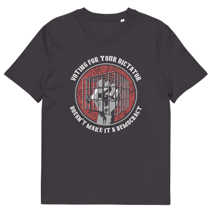 An anthracite short-sleeve t-shirt with a circular graphic on the chest. The graphic features a red distressed background with a white silhouette of a person behind bars, surrounded by the text 'VOTING FOR YOUR DICTATOR' on top and 'DON'T MAKE IT A DEMOCRACY' on the bottom.
