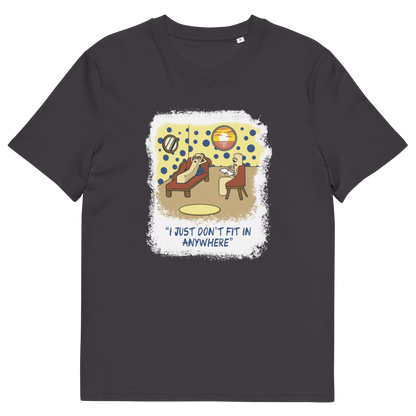 An anthracite grey short-sleeve t-shirt with a central graphic print. The graphic features a cartoon illustration of a person sitting on a lounge chair in a theorists room , with a white distressed border and the text 'I JUST DON'T FIT IN ANYWHERE' below.