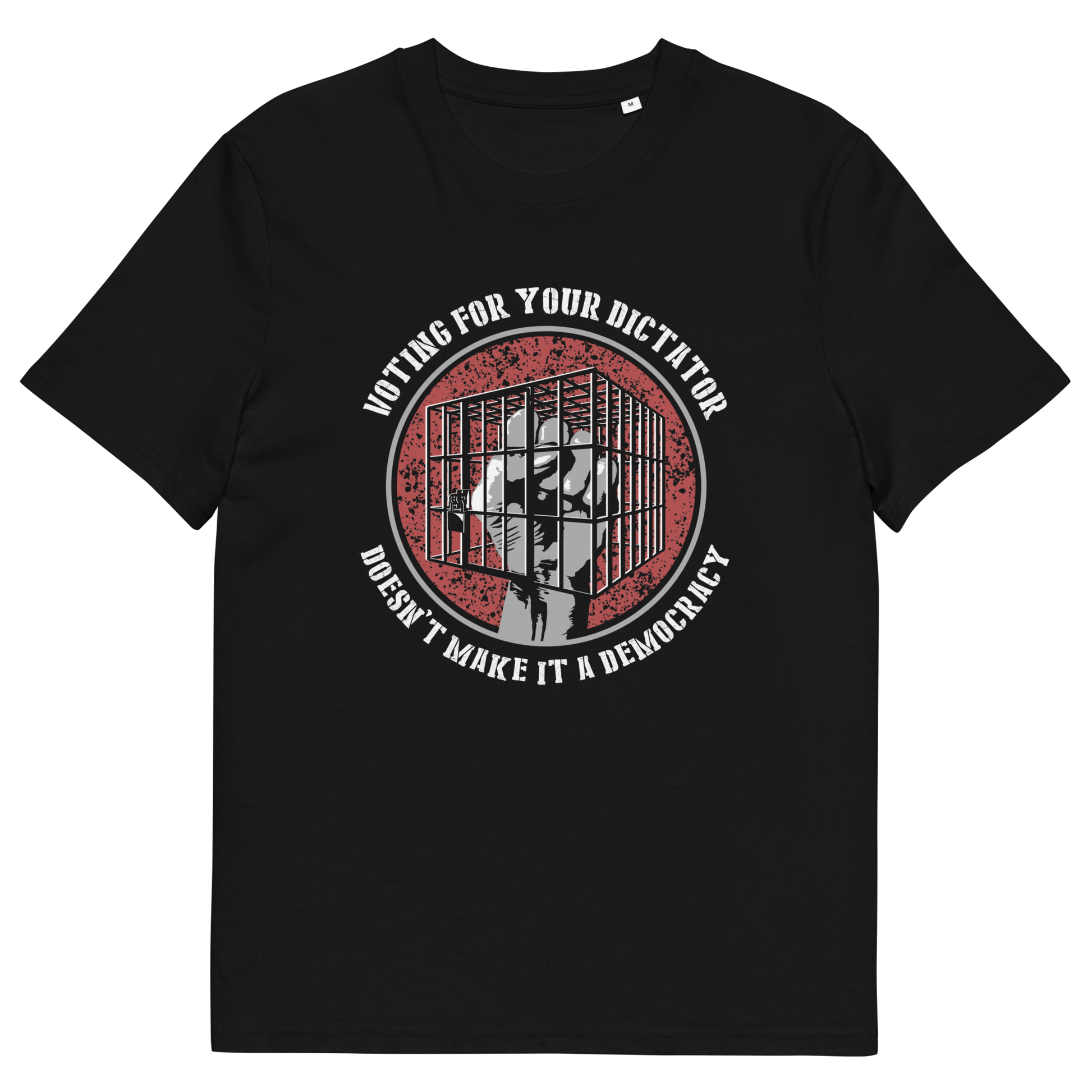 A black short-sleeve crewneck t-shirt with a circular graphic on the chest. The graphic features a red distressed background with a white silhouette of a person behind bars, surrounded by the text 'VOTING FOR YOUR DICTATOR DOESN'T MAKE IT A DEMOCRACY' in white.