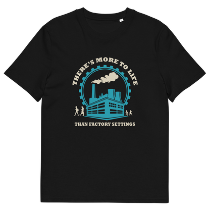 A black short-sleeve crewneck t-shirt with a vintage-style graphic on the chest. The graphic features a teal and cream illustration of a factory building under a circular gear, with the text 'THERE'S MORE TO LIFE THAN FACTORY SETTINGS' in cream.