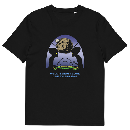 A black short-sleeve crewneck t-shirt featuring a retro sci-fi graphic of two alien silhouettes looking at a planet, with the text 'WELL IT DIDN'T LOOK LIKE THIS IN 1947' printed below.