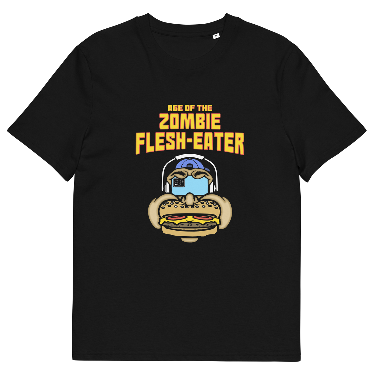 A black short-sleeve crewneck t-shirt with a graphic on the front. The graphic features the text 'AGE OF THE ZOMBIE FLESH-EATER' in yellow, above a cartoon zombie head wearing headphones and biting a burger.
