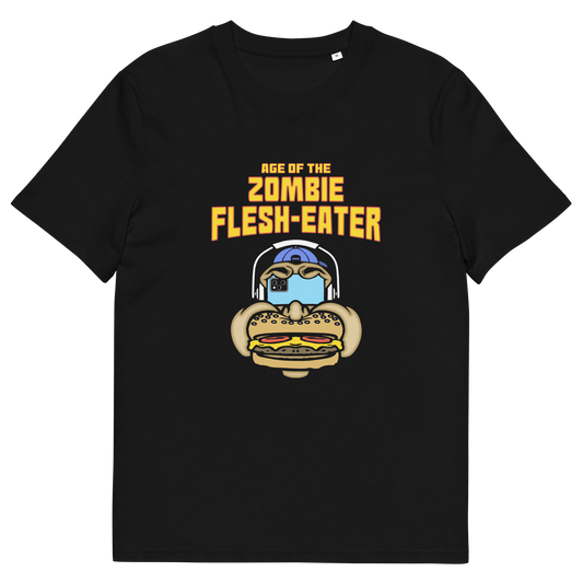 A black short-sleeve crewneck t-shirt with a graphic on the front. The graphic features the text 'AGE OF THE ZOMBIE FLESH-EATER' in yellow, above a cartoon zombie head wearing headphones and biting a burger.