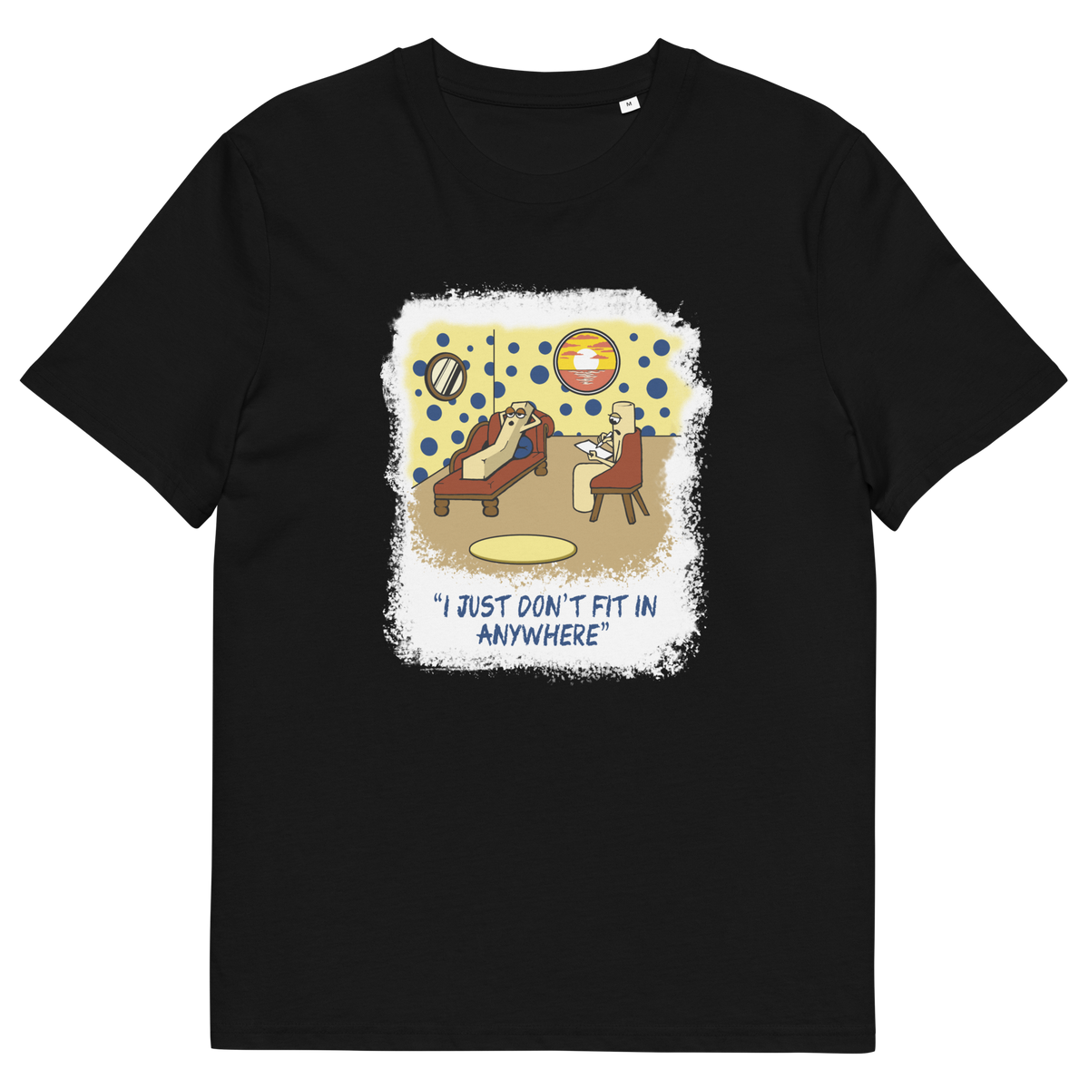 A black short-sleeve crewneck t-shirt with a central graphic print. The graphic features a cartoon illustration of a person sitting on a lounge chair in a theorists room , with a white distressed border and the text 'I JUST DON'T FIT IN ANYWHERE' below.