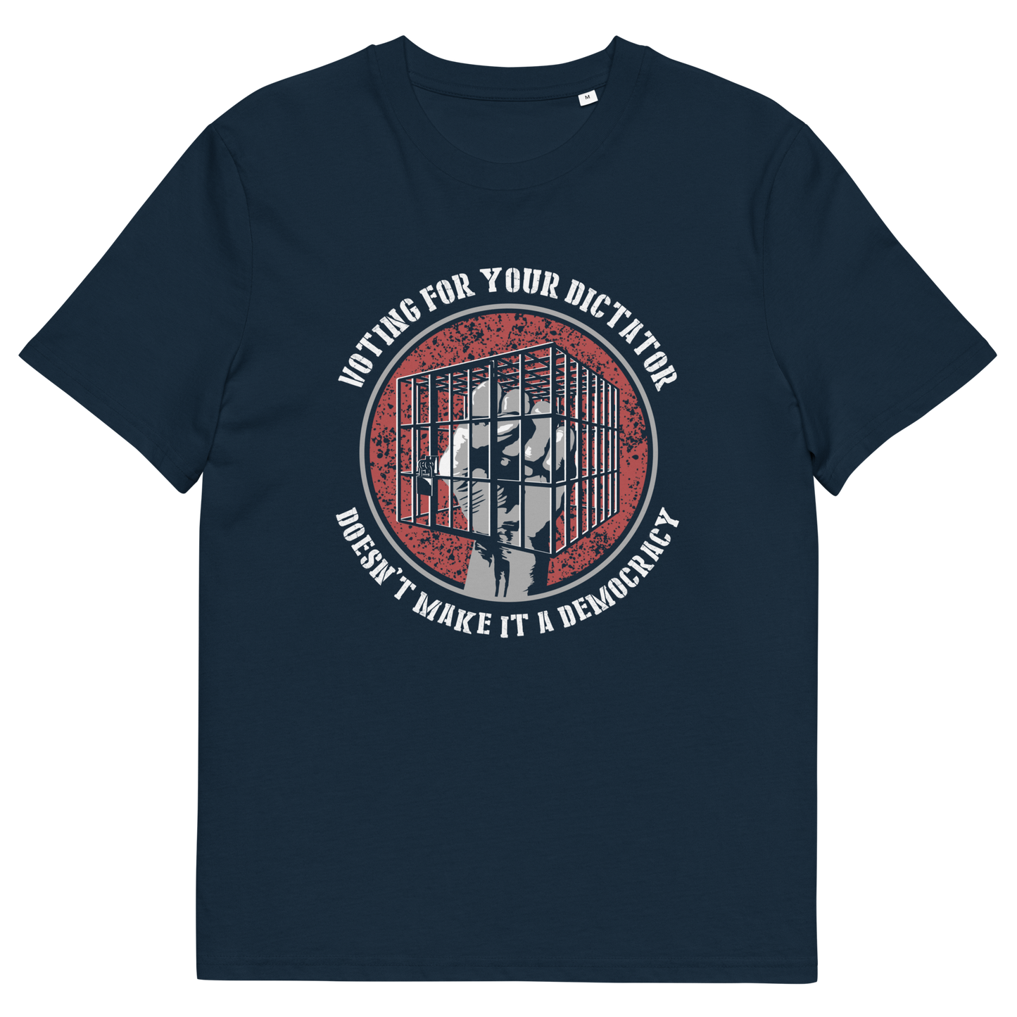 A French navy blue short-sleeve t-shirt with a circular graphic on the chest. The graphic features a distressed red background with a white silhouette of a person behind bars, surrounded by the text 'VOTING FOR YOUR DICTATOR' on top and 'DOESN'T MAKE IT A DEMOCRACY' below.