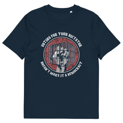 A French navy blue short-sleeve t-shirt with a circular graphic on the chest. The graphic features a distressed red background with a white silhouette of a person behind bars, surrounded by the text 'VOTING FOR YOUR DICTATOR' on top and 'DOESN'T MAKE IT A DEMOCRACY' below.
