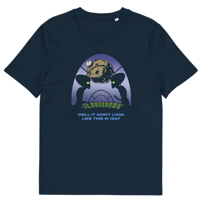 A navy blue short-sleeve crewneck t-shirt featuring a retro sci-fi graphic of two alien silhouettes looking at a planet, with the text 'WELL IT DIDN'T LOOK LIKE THIS IN 1947' printed below.