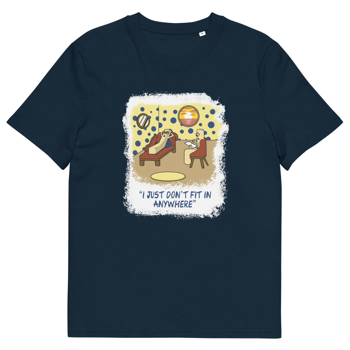 A French navy blue short-sleeve crewneck t-shirt with a central graphic print. The graphic features a cartoon illustration of a person sitting on a lounge chair in a theorists room , with a white distressed border and the text 'I JUST DON'T FIT IN ANYWHERE' below.