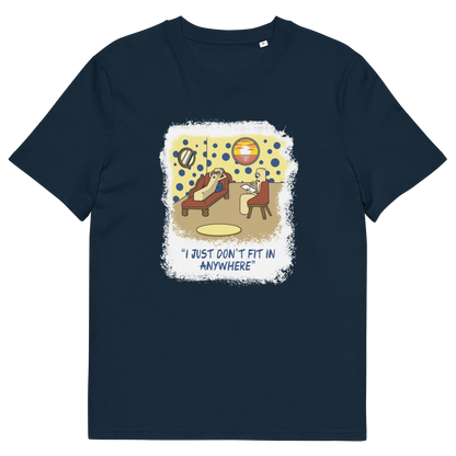 A French navy blue short-sleeve crewneck t-shirt with a central graphic print. The graphic features a cartoon illustration of a person sitting on a lounge chair in a theorists room , with a white distressed border and the text 'I JUST DON'T FIT IN ANYWHERE' below.