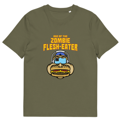 Khaki t-shirt with a graphic on the front. The graphic features the text 'AGE OF THE ZOMBIE FLESH-EATER' in yellow, above a cartoon zombie head wearing headphones and biting a burger.