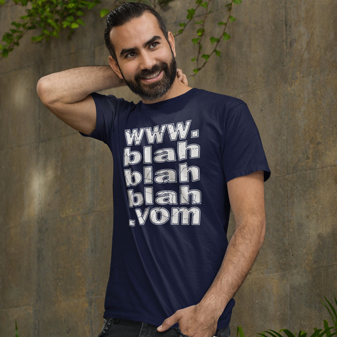Man standing outside, scratching his neck, wearing a French navy blue t-shirt with "www.blahblahblah.vom" text design.